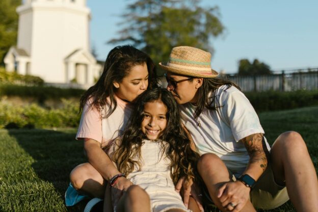 family sitting on green grass field